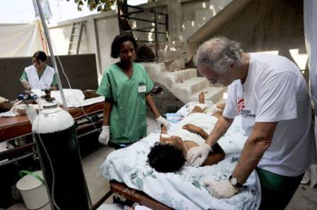 British surgeon, Paul McMaster, treats patients in a makeshift MSF surgery outside Carrefour hospital